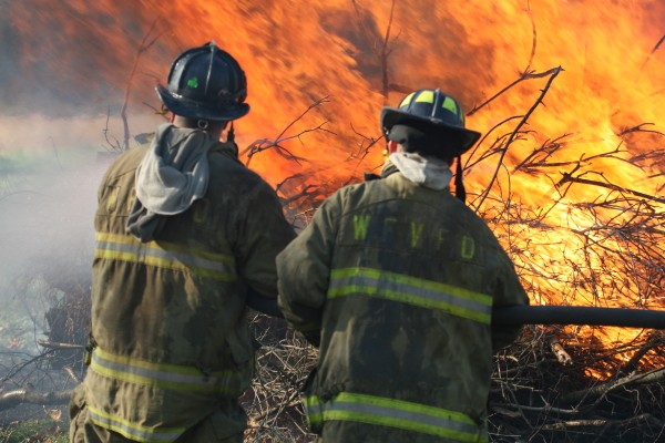 Justin Sosebee and Jimmy Garratt monitoring a pile of brush burning. - Transco Road