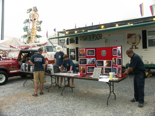 Assistant Chief Mark Miller, Jon Mckee, Matthew Saunders, Chris Saunders prepare the recruitment stand.