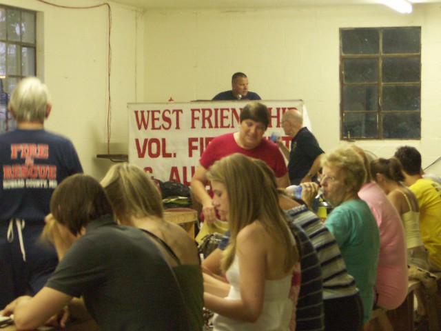 Fair goers sit down for a game of Bingo as John Mills calls the next number. Shirley Mills, Donald Ridgely, and Jim Piersall await the next winner. 